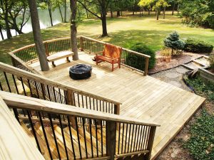 A Signature Decks and Construction project with stairs leading to a patio deck surrounding a fire pit.