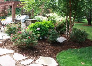 A patio design by Signature Decks & Construction. Next to a composite decking project with a pergola.