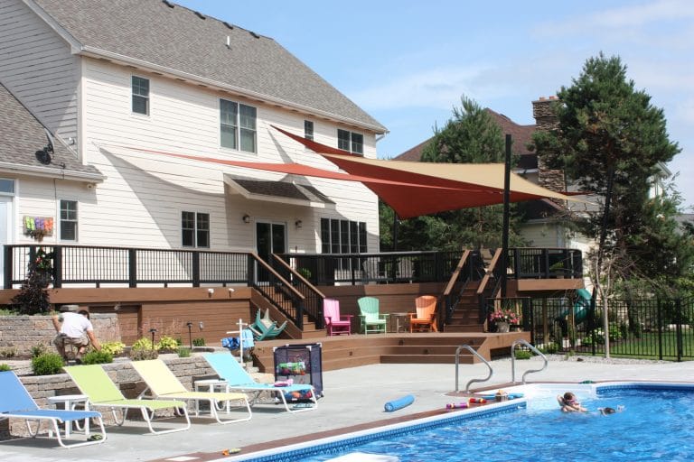 How much does a custom deck cost? Well, that depends on your budget. A custom Signature deck, multi levels with sails, a grilling station, and a patio space leading to an in-ground pool.