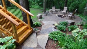 A deck staircase leads to landscaping in a backyard. For deck builders in Ada MI, trust Signature Decks & Construction.