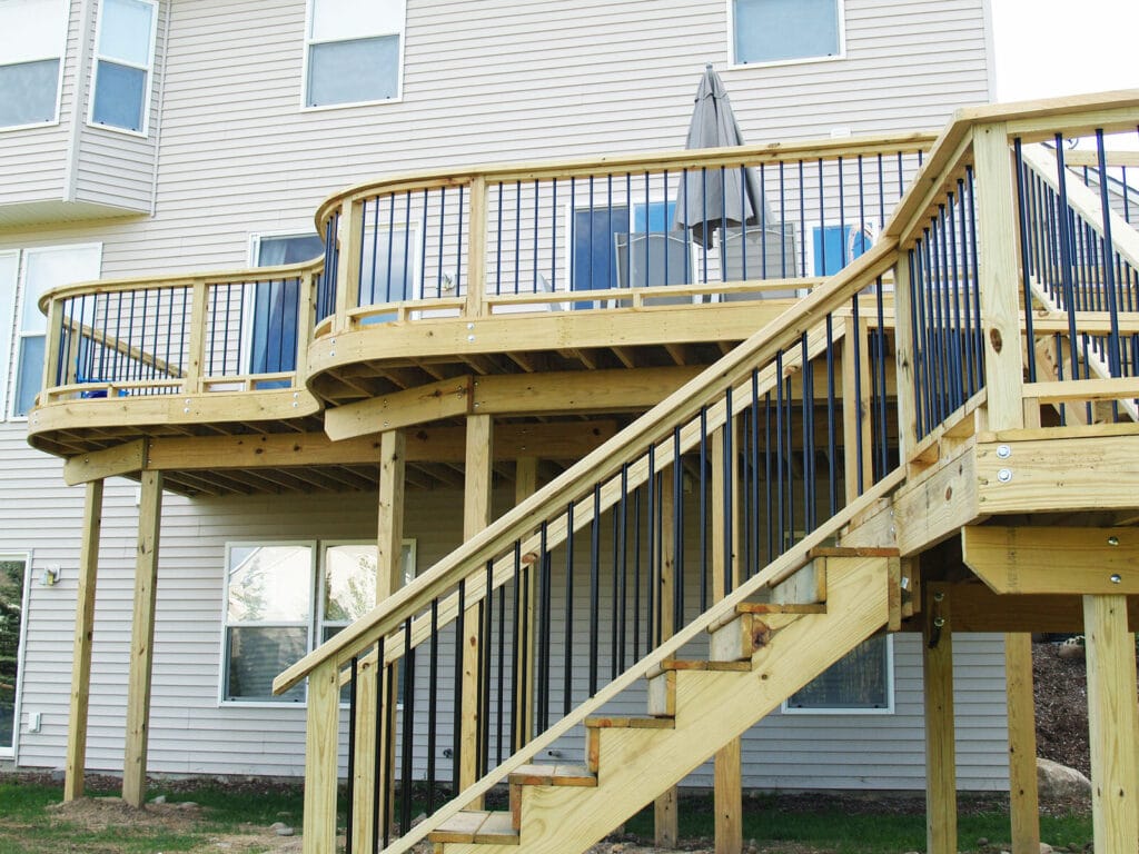 A classic deck off of the back of a house by Signature Decks and Construction.