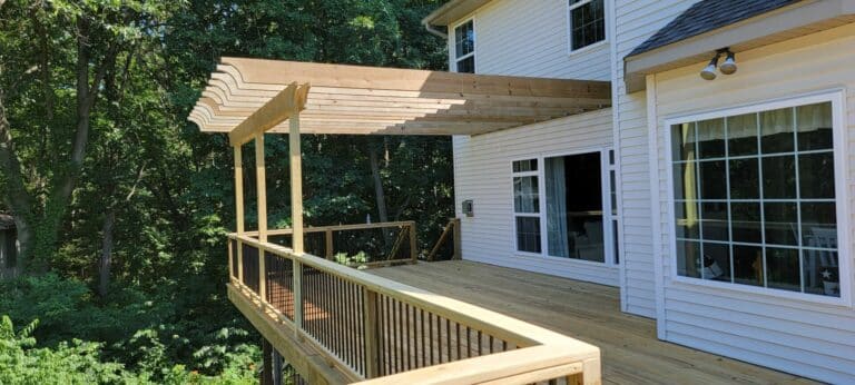An outdoor second story deck combined with a pergola for shade by Signature Decks.
