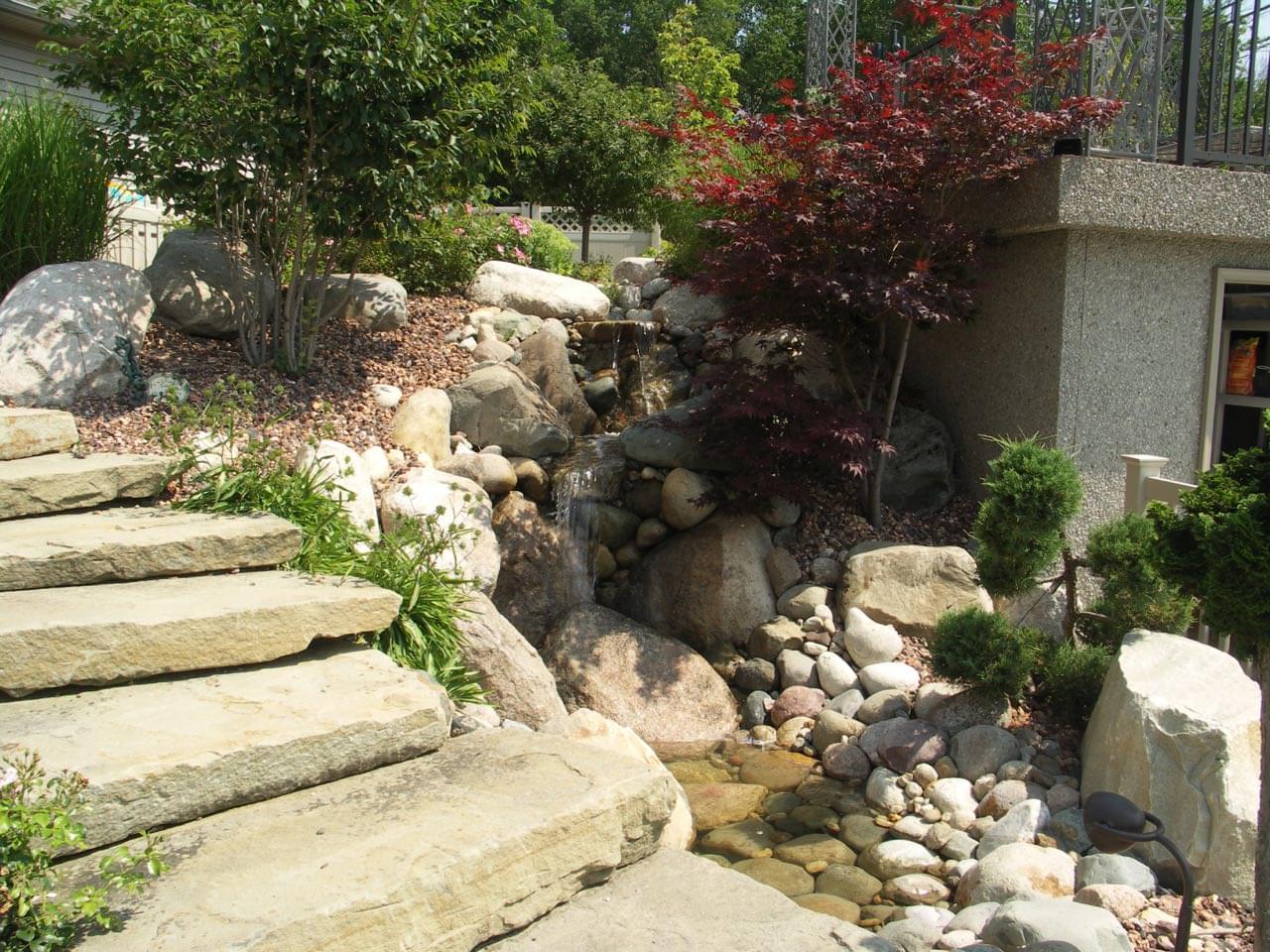 Signature Decks & Construction pairs itself with a landscaping architect to make your landscaping ideas come to life. A limestone rock pattern added onto a family home's backyard patio.