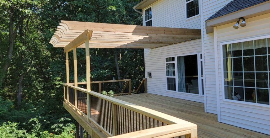 An outdoor second story deck combined with a pergola for shade by Signature Decks.