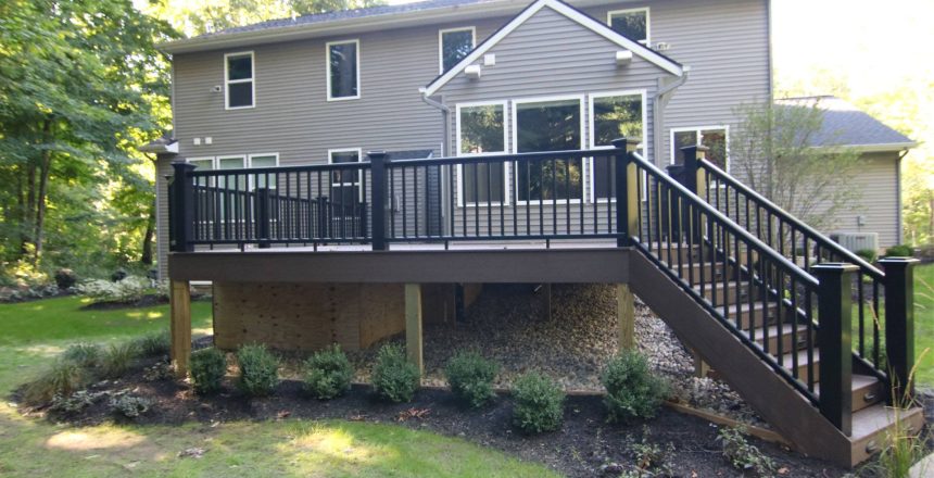 Deck elevation is an important requirement during the construction process. An elevated deck off a sloped backyard of a house.