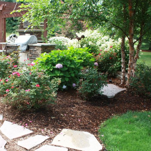 A patio design by Signature Decks & Construction. Next to a composite decking project with a pergola.